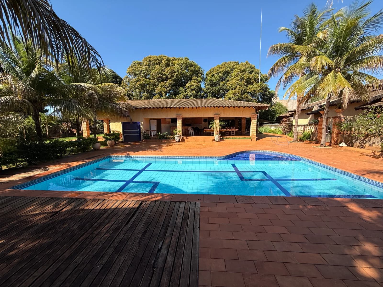 Família aproveitando piscina privativa de rancho à beira da represa nas férias de janeiro no interior de SP