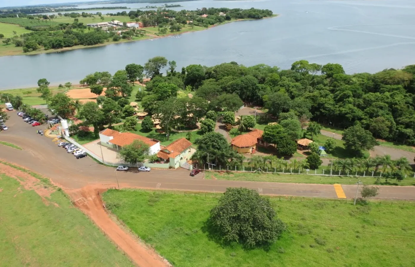 Vista aérea do Parque Ecoturístico das Águas em Santa Fé do Sul com chalés e quiosques à beira da represa